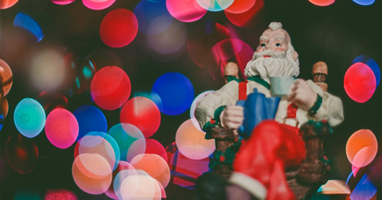 Father Christmas toy in front of lights