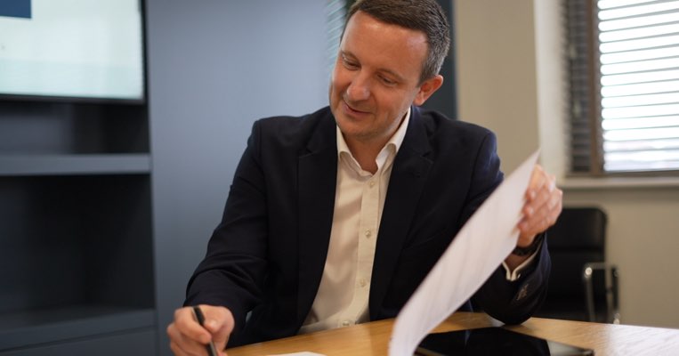 Sales, Lettings and Mortgage Advisor signing paper