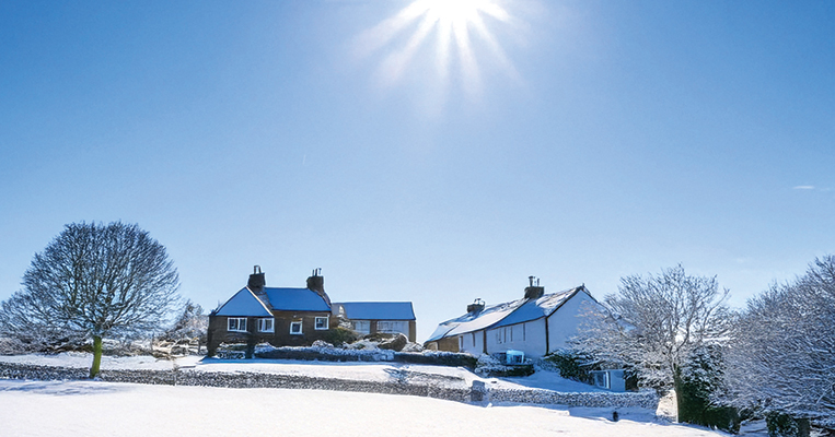 Wintery countryside with building covered in snow